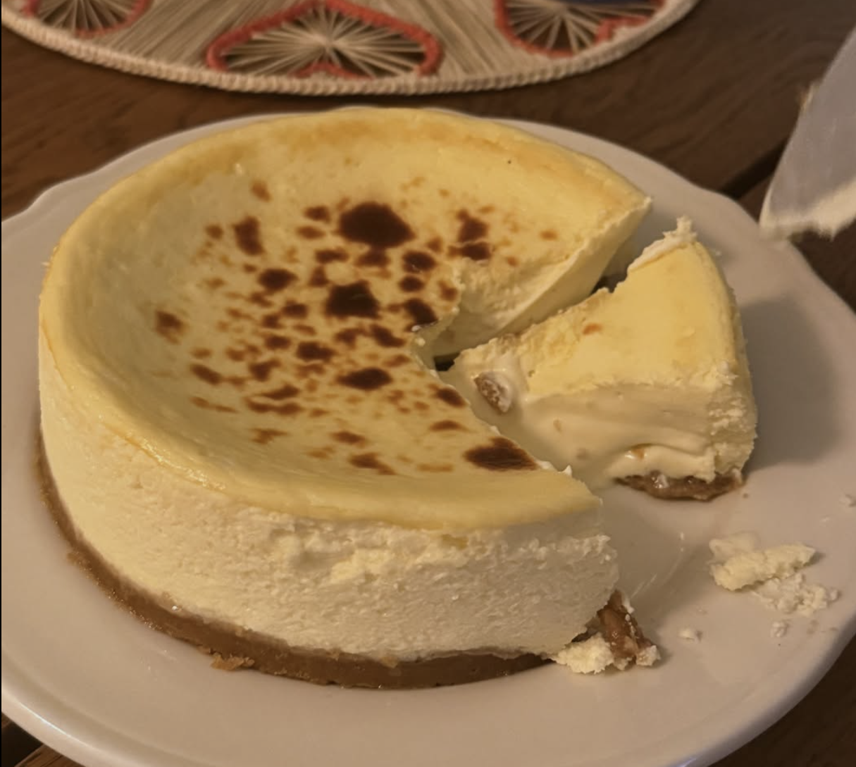 Cut tarta de queso on a plate with a creamy slice removed.